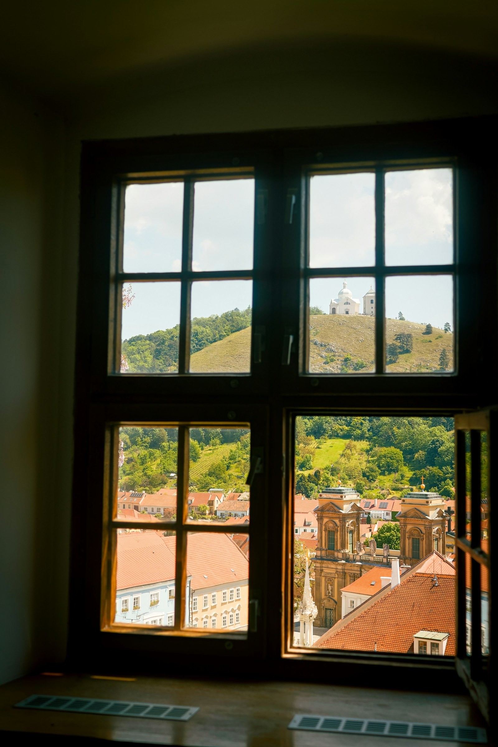 View from a window across the roofs of Mikulov to Holy Hill